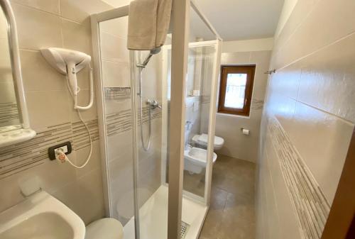 平佐洛Casteluce Hotel Funivie的带淋浴、卫生间和盥洗盆的浴室