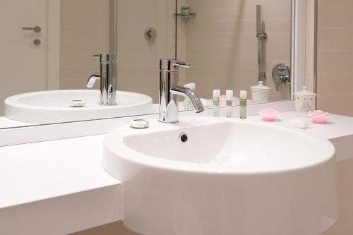 维洛尔巴UNAHOTELS Le Terrazze Treviso Hotel & Residence的白色的浴室设有水槽和镜子