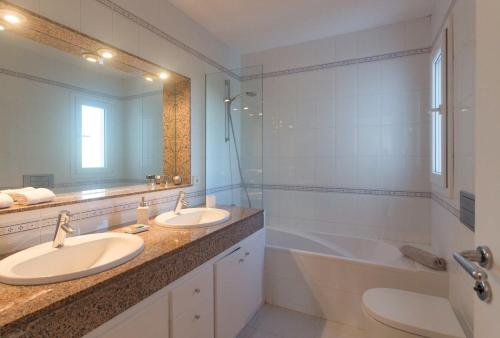 伊维萨镇Villa Casiopea的一间带两个盥洗盆和大镜子的浴室