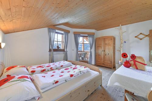 科尔皮缇亚Ebenhof的一间卧室设有两张床和木制天花板