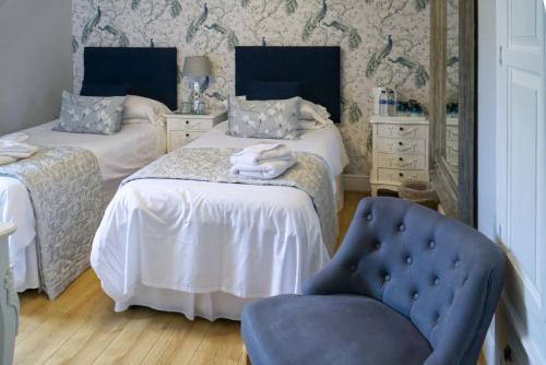 剑桥The Cambridge Guest House by Tas的一间卧室配有两张床和一张蓝色椅子