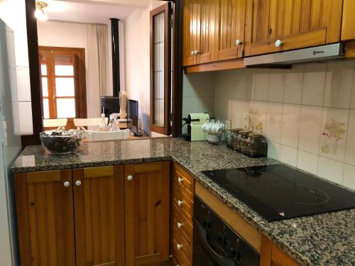 莫雷拉Casa San Nicolás的厨房配有木制橱柜和黑色台面