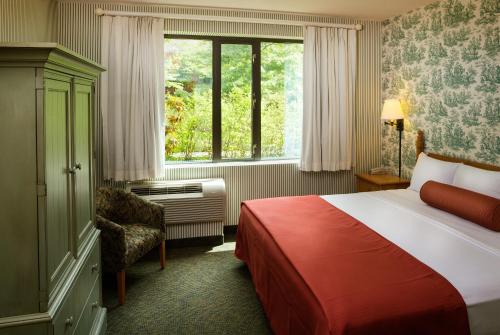 威廉斯堡Williamsburg Woodlands Hotel & Suites, an official Colonial Williamsburg Hotel的酒店客房设有床和窗户。