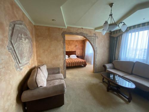 乌日霍罗德Intourist-Zakarpattia Hotel的客厅配有沙发和1张床