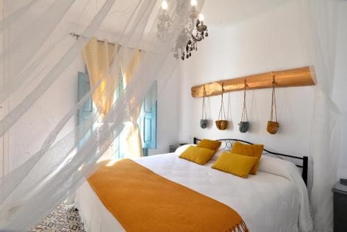 努瓦洛斯La Boutique的一间卧室配有一张带黄色枕头的床和一扇窗户