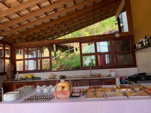 特林达德Espaço Indio Tupi的厨房配有一张桌子,里面摆放着面包和糕点