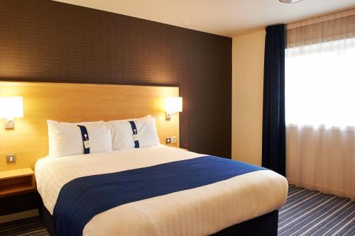 霍尔曼彻斯特机场智选假日酒店的一间设有大床和窗户的酒店客房