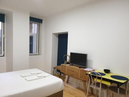 里斯本阿尔法玛服务公寓的一间卧室配有一张床和一张带电脑的书桌