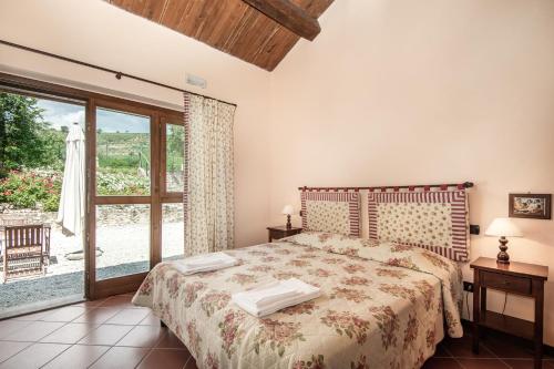 斯波莱托伊尔卡萨里诺度假农庄的一间卧室设有一张床和一个大窗户