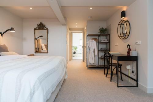 阿姆斯特丹Empire suites roof terras的一间卧室配有一张床、一张书桌和一面镜子