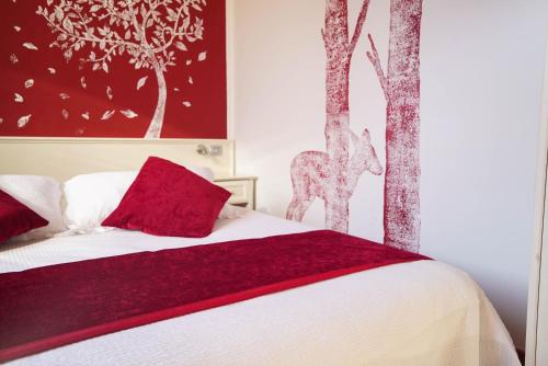 GrizzanaHotel Il Crinale的一间卧室配有一张带红色枕头和树木的床