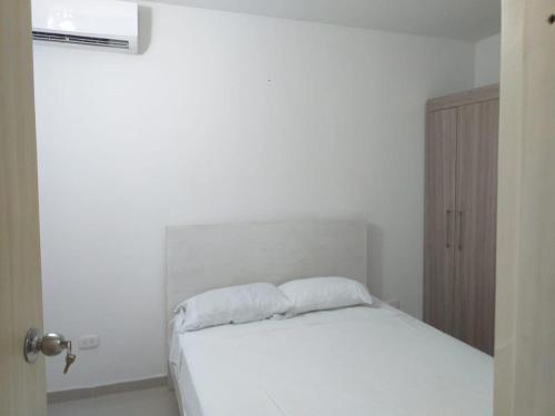 蒙特里亚Apartamento con piscina的卧室配有白色的床铺和白色的枕头