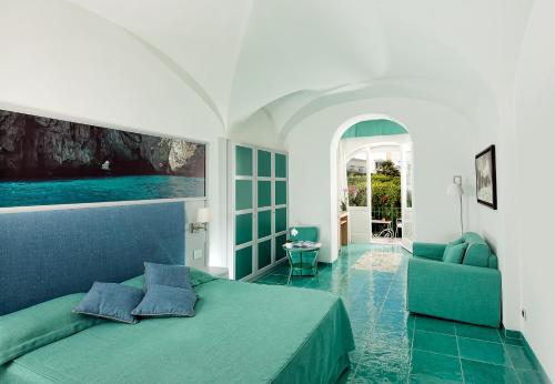 卡普里阿尔贝格加托比昂科酒店的一间卧室配有绿色的床和沙发