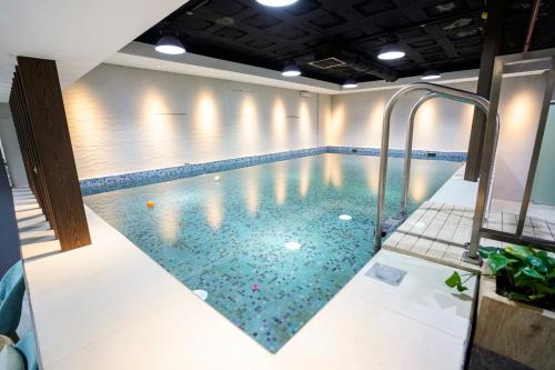利雅德Vivian Park Hotel Suites的一座铺有瓷砖地板的室内游泳池