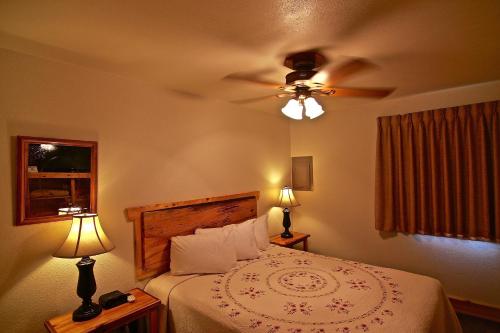 加德纳Yellowstone Village Inn and Suites的一间卧室配有一张带吊扇的床