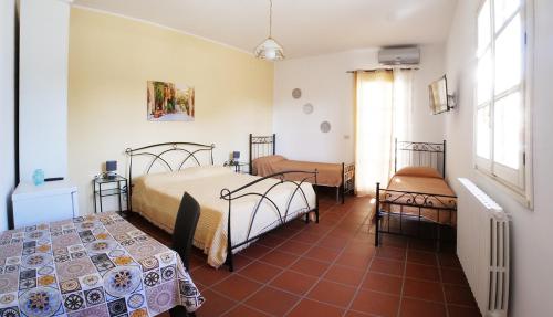 SternatiaB&B Amèsa的一间卧室设有两张床,铺有红色瓷砖地板。
