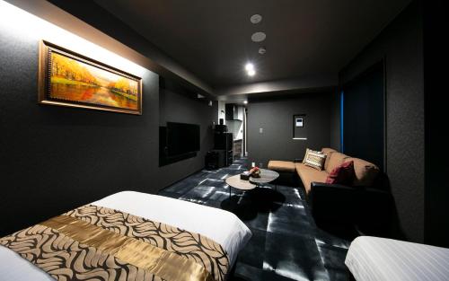 高松GRAND BASE Takamatsu的酒店客房,配有床和沙发