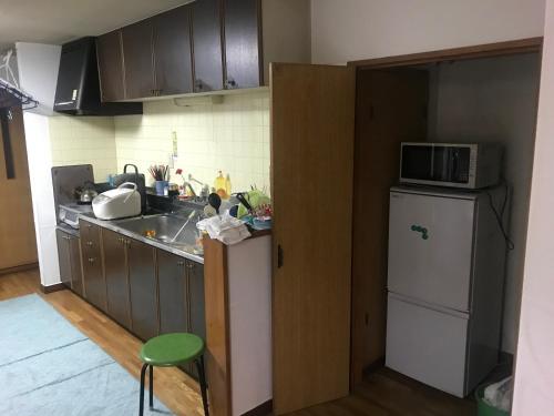 小樽Otaru stay的厨房配有水槽、微波炉和冰箱