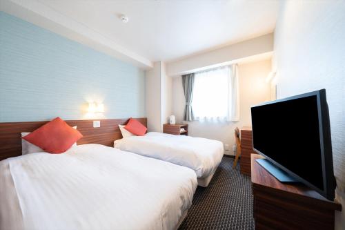 东京瑞珍珠酒店的酒店客房设有两张床和一台平面电视。