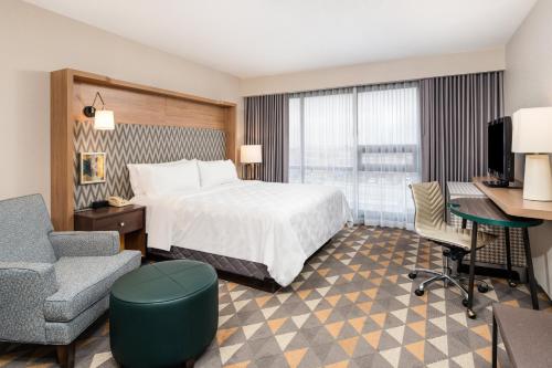 多伦多多伦多机场东假日酒店的酒店客房配有一张床、一张桌子和一把椅子。