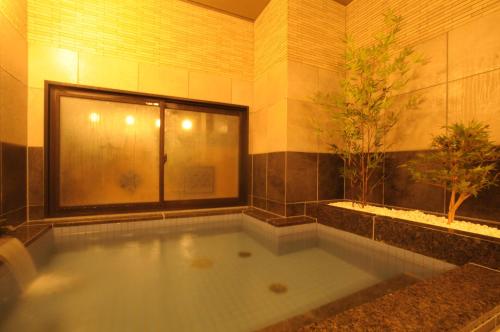 宇部AB Hotel Ubeshinkawa的浴室设有大浴缸,里面有一棵树