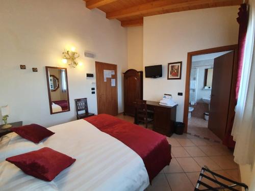 法瓦罗威尼托Agriturismo Eva的酒店客房设有一张床、一张书桌和一间浴室。