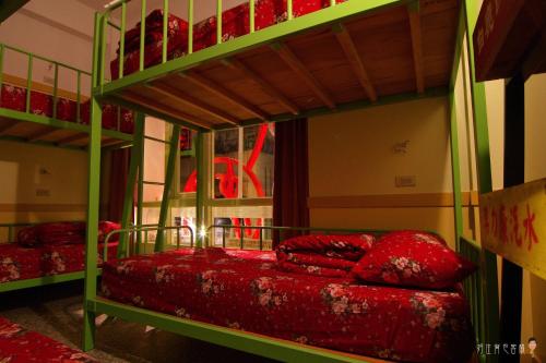 北港镇北港好住背包客棧的一间卧室配有两张双层床和红色枕头