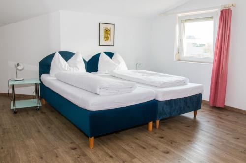 因斯布鲁克Wohnen in Innsbruck的一张蓝色的床,上面有白色枕头