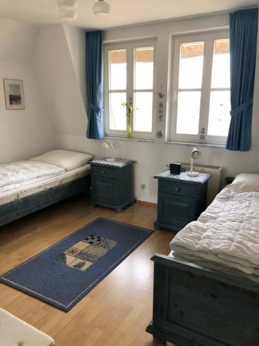 施托尔佩奥夫乌塞多姆Refugium Raabenhorst im Landhaus am Haff的一间卧室设有两张床和两个窗户。