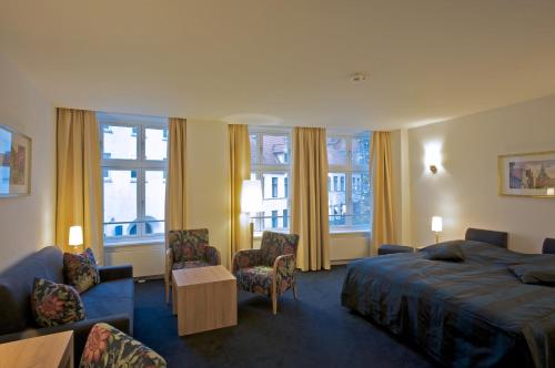 吕讷堡Hotel Bremer Hof的酒店客房带一张床、椅子和窗户