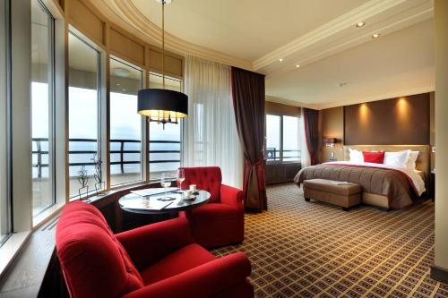 海滨诺德韦克Grand Hotel Huis ter Duin的酒店客房,配有一张床和一张红色的沙发