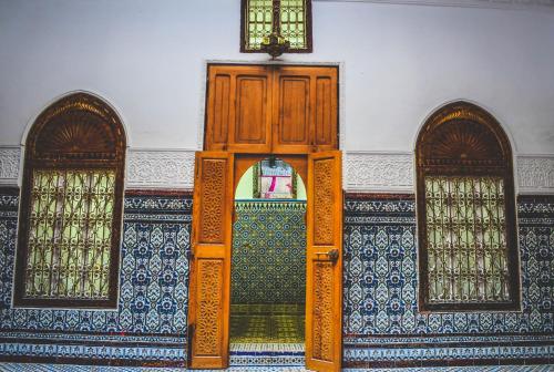 得土安Riad Tetuanía的一个带两扇窗户的房间的敞门