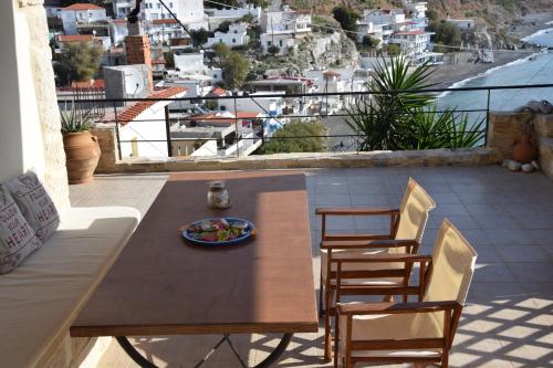 ParánimfoiAeriko House的观景阳台配有一张木桌和椅子。