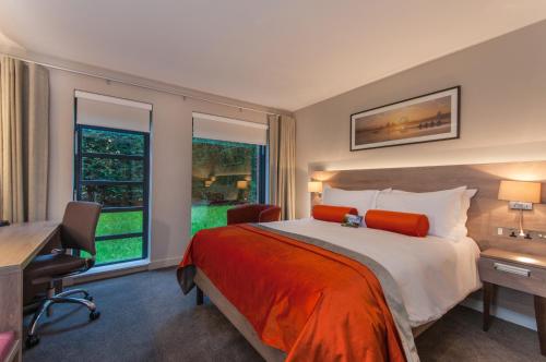 亨利昂泰晤士Greenlands Hotel的一间卧室配有一张床、一张书桌和一个窗户。