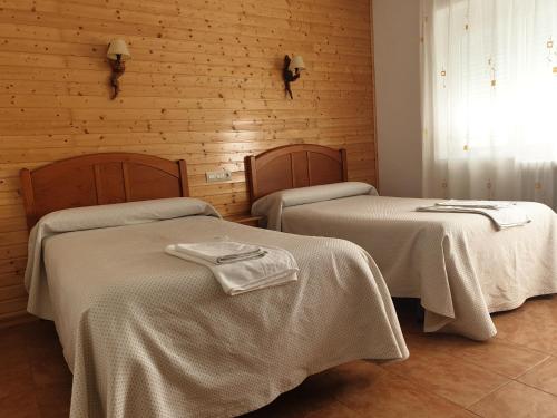 里奥帕尔里奥蒙多旅馆的客房设有2张带白色床单的床和窗户。