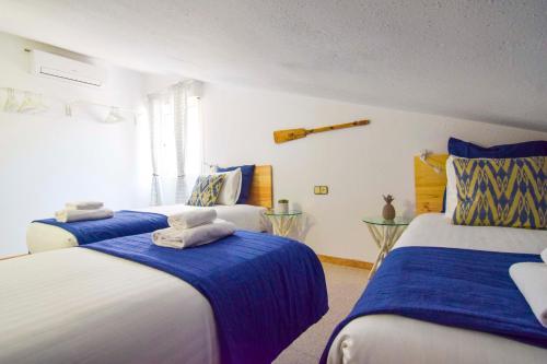 马拉加Letmalaga Cremades Sea Views的一间卧室配有两张带蓝白色床单的床