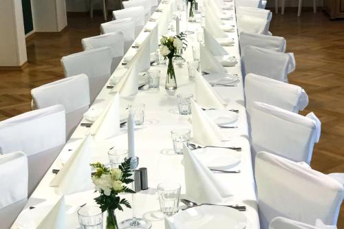 什切青Dom św. Józefa的一张长桌子,上面有白色的桌子和白色的椅子
