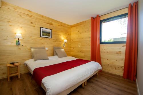 瑟鲁堡Village de vacances Les Lambrilles的一间卧室设有一张大床和窗户