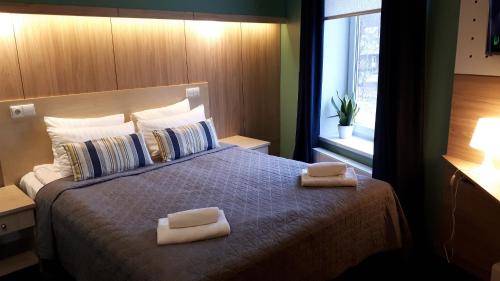 尤尔马拉阿尔巴酒店的一间卧室配有一张床,上面有两条毛巾