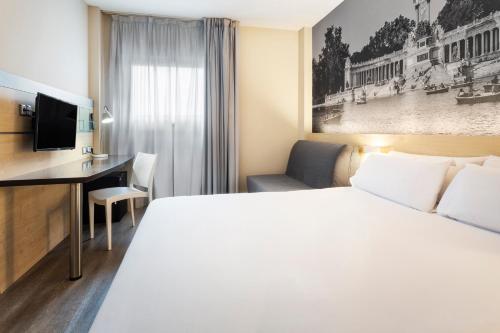 马德里B&B HOTEL Madrid Aeropuerto T1 T2 T3的配有一张床和一张书桌的酒店客房