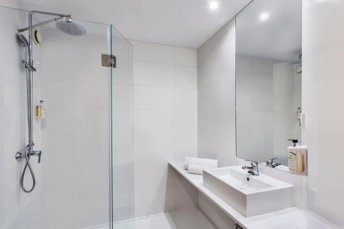 马德里B&B HOTEL Madrid Aeropuerto T1 T2 T3的白色的浴室设有水槽和淋浴。
