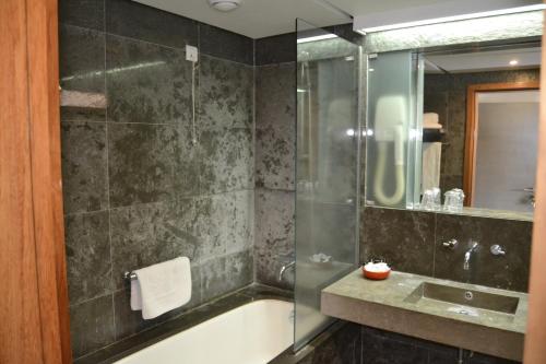 英雄港英雄港塞巴斯蒂昂城堡酒店的带淋浴、浴缸和盥洗盆的浴室