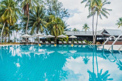 刁曼岛刁曼岛成功度假村的一座棕榈树和遮阳伞的游泳池