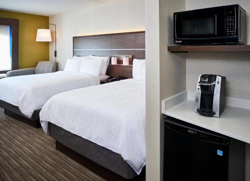 滨湖尼亚加拉Holiday Inn Express Niagara-On-The-Lake, an IHG Hotel的一间酒店客房,设有两张床和电视