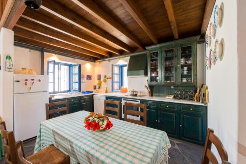 卡拉索斯利特萨度假屋的厨房配有绿色橱柜和鲜花桌