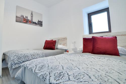 贝赫尔-德拉弗龙特拉Casa Luminosa, junto al Castillo的一间卧室配有两张带红色枕头的床