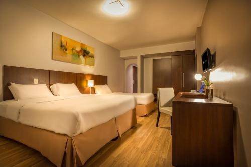 圣保罗H3 Hotel Paulista的酒店客房配有两张床和一张书桌