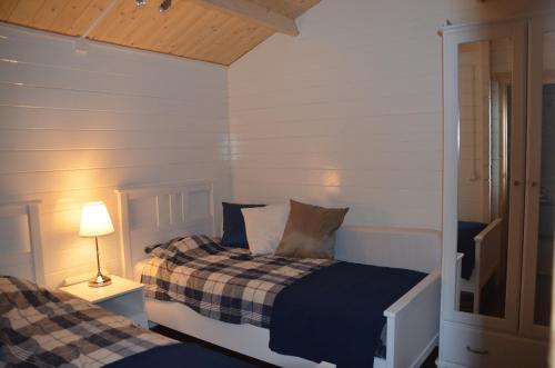 KlarenbeekChalet t Kla-viertje的一间卧室设有两张床和一张桌子上的台灯。