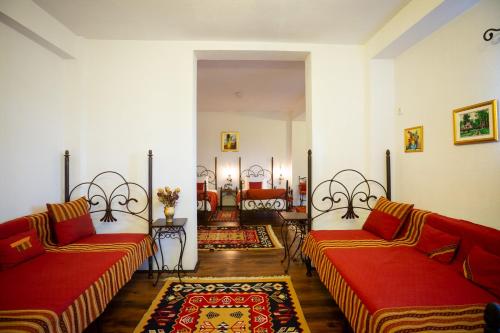 布泽乌Complex Turistic "Moara Dragaicilor"的客厅配有两张红色的沙发和地毯。