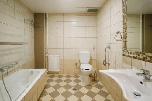 拉米亚雅典娜酒店的带浴缸、卫生间和盥洗盆的浴室